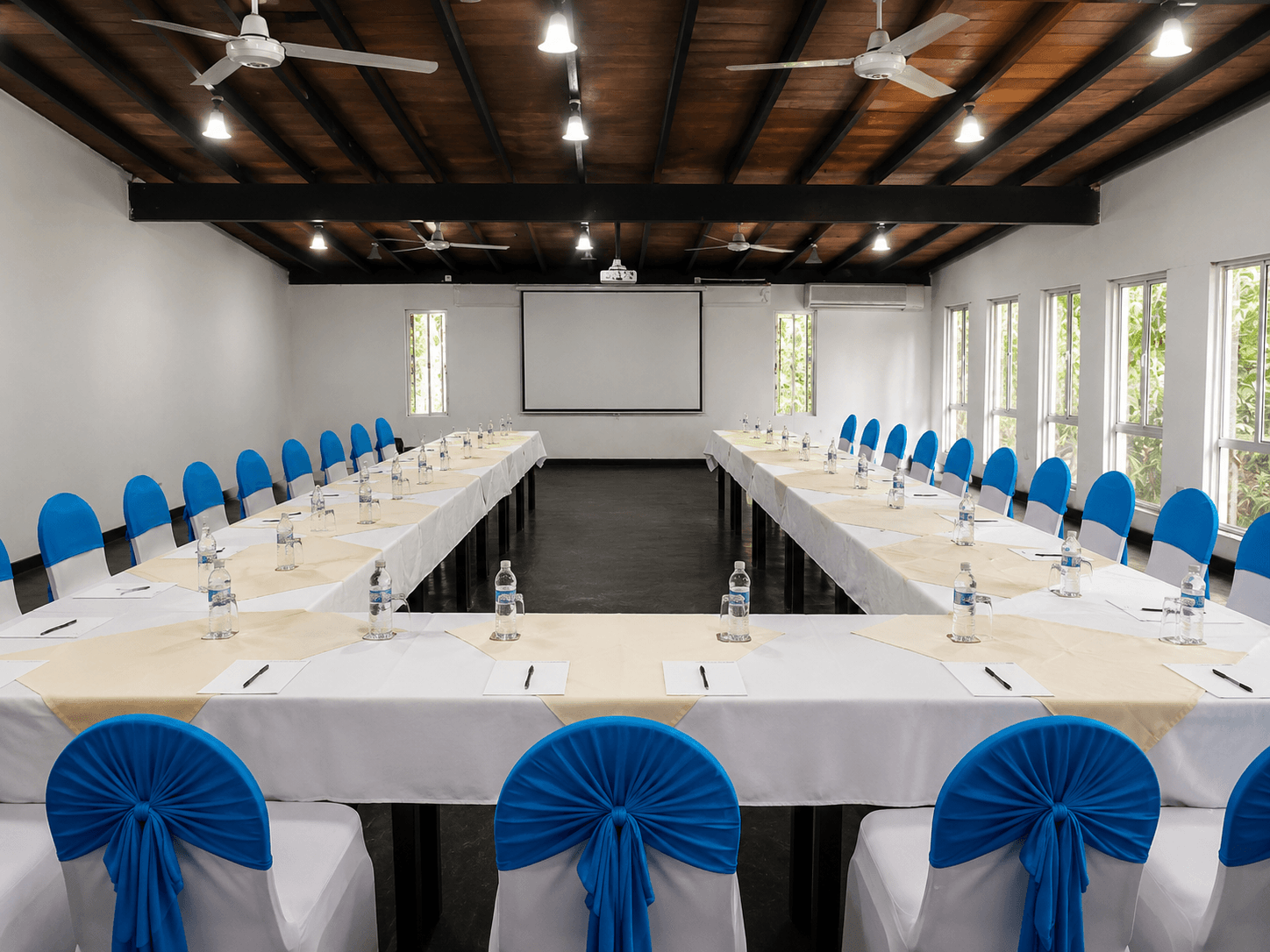 A large conference room set up for a meeting with many chairs and tables.